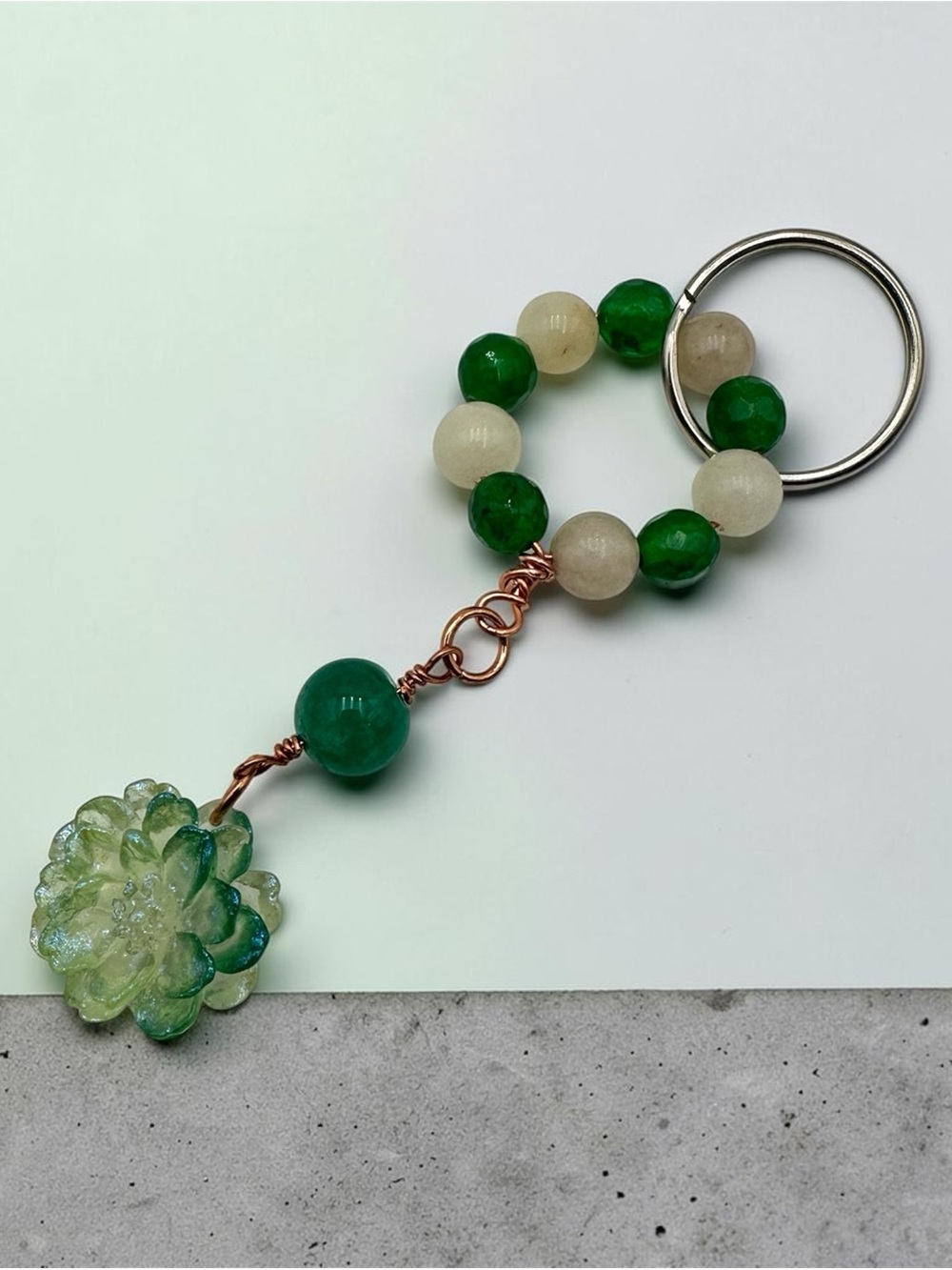 Handmade green and cream beaded keychain featuring a beautiful flower charm and